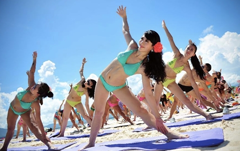 Yoga during a seaside bikini festival on Wuzhizhou Island of Sanya, China –